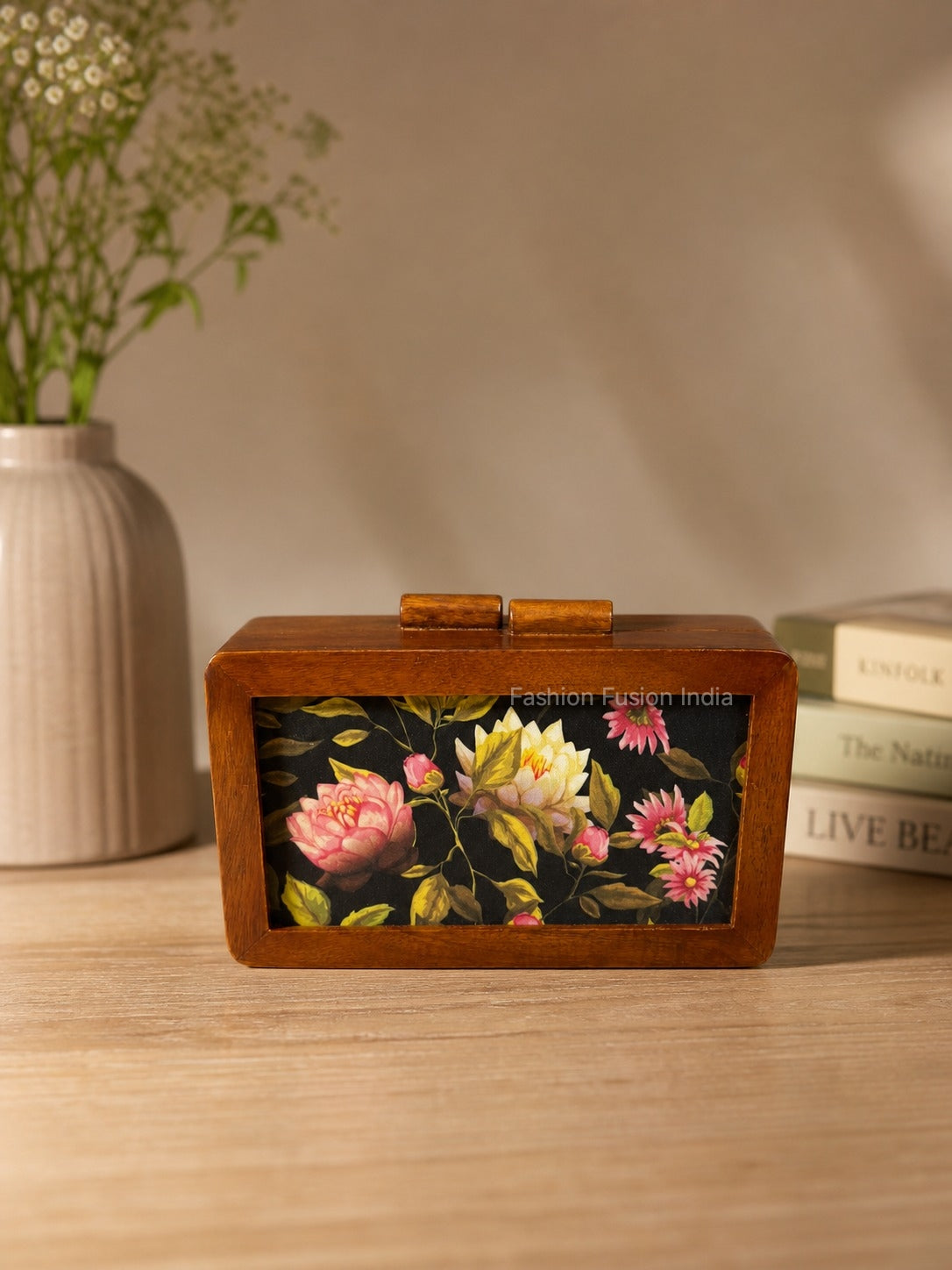 Wooden box clutch with elegant floral print against carved grey backdrop.