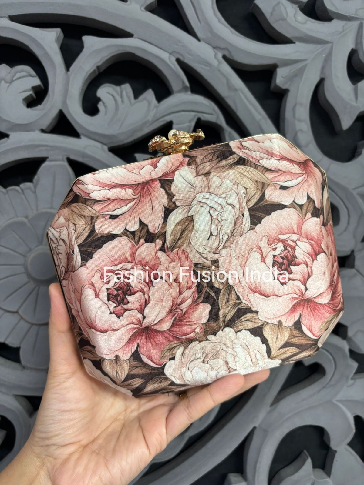 Floral clutch held by a hand with decorative background