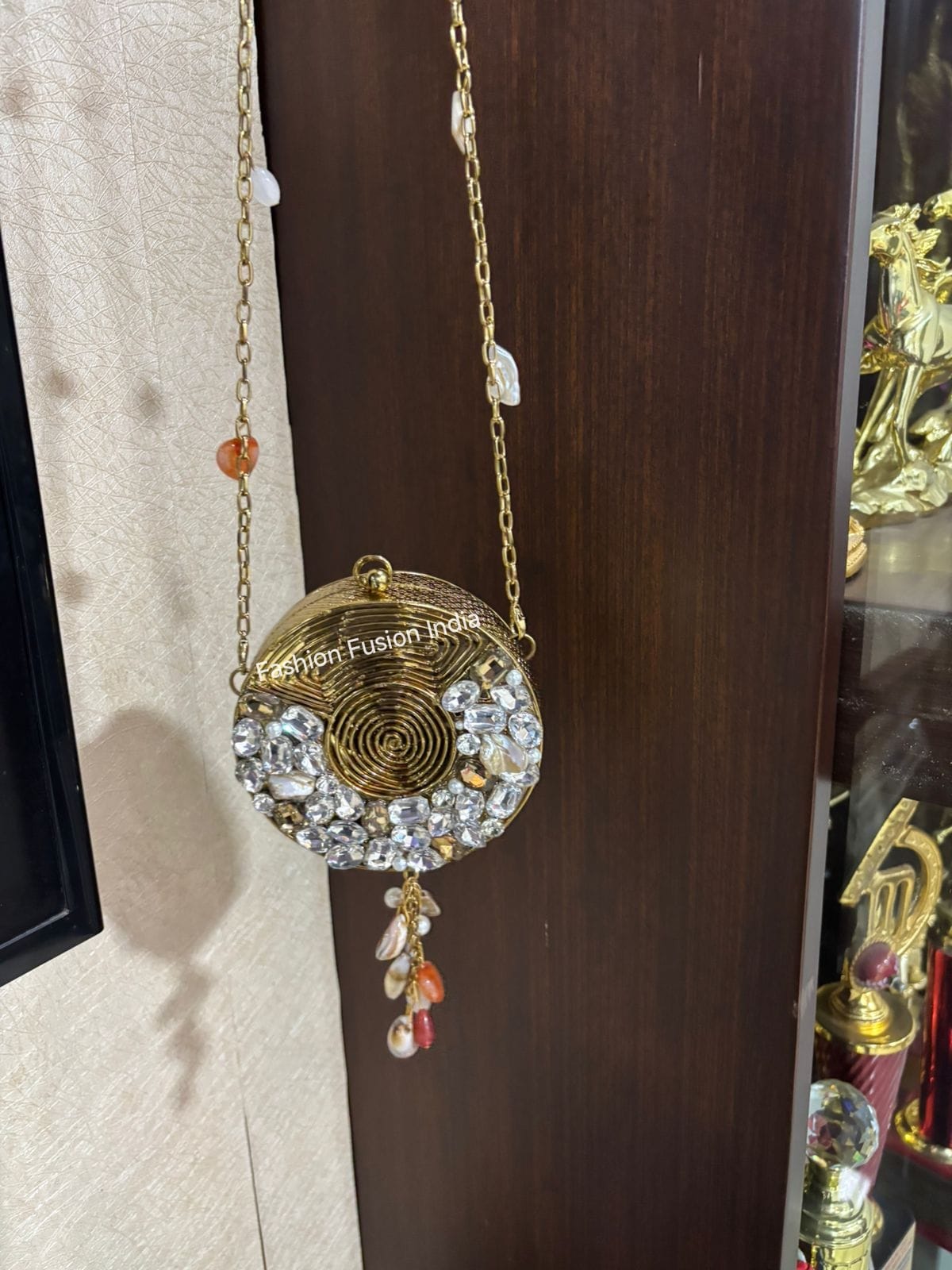 Decorative hanging ornament with intricate design and 'Vishram Fusion Jewels' branding on a wooden surface.