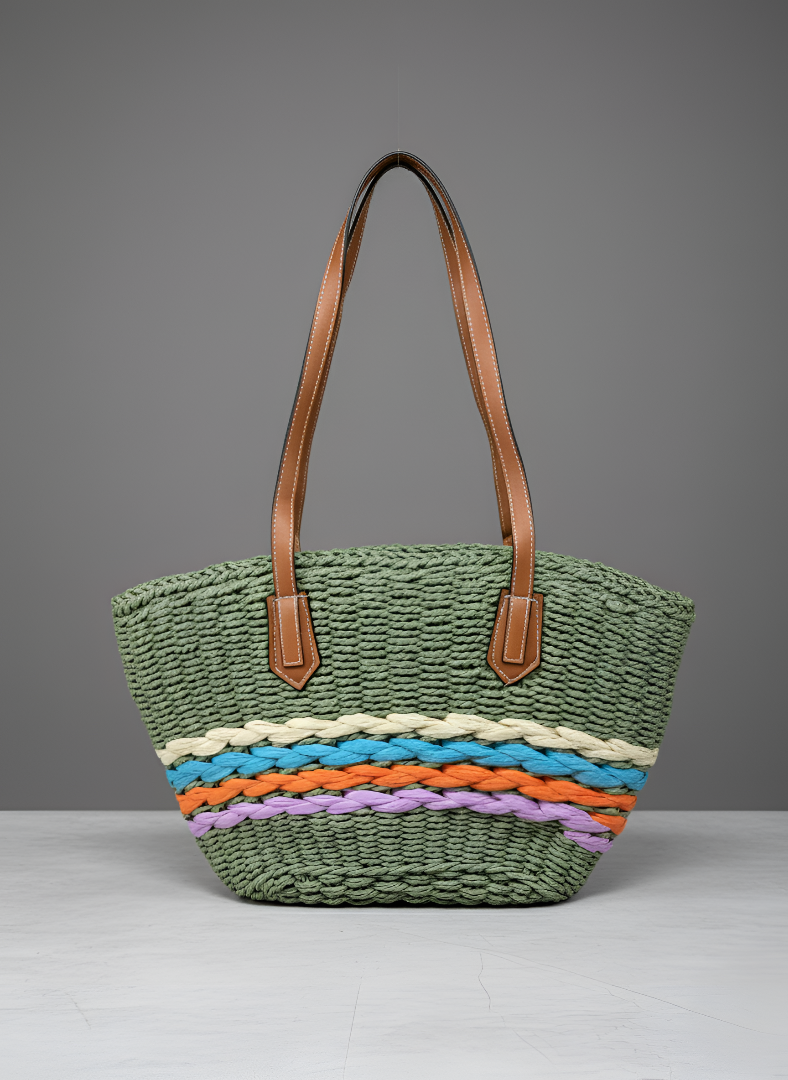 Green woven bag with colorful stripes and brown handles on a gray background
