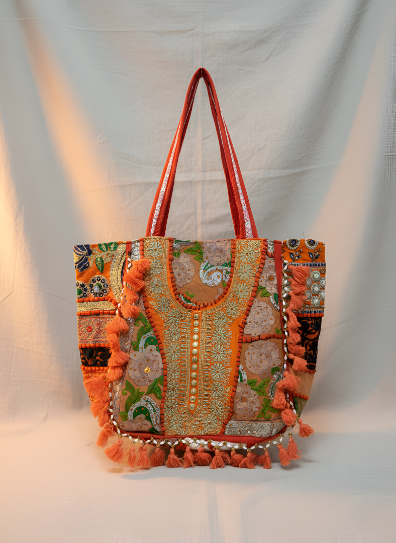 Decorative handbag with intricate patterns and tassels on a plain background