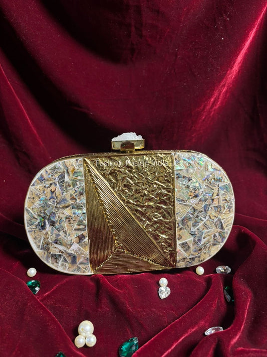 Decorative gold clutch on a red velvet surface with scattered pearls and gemstones.