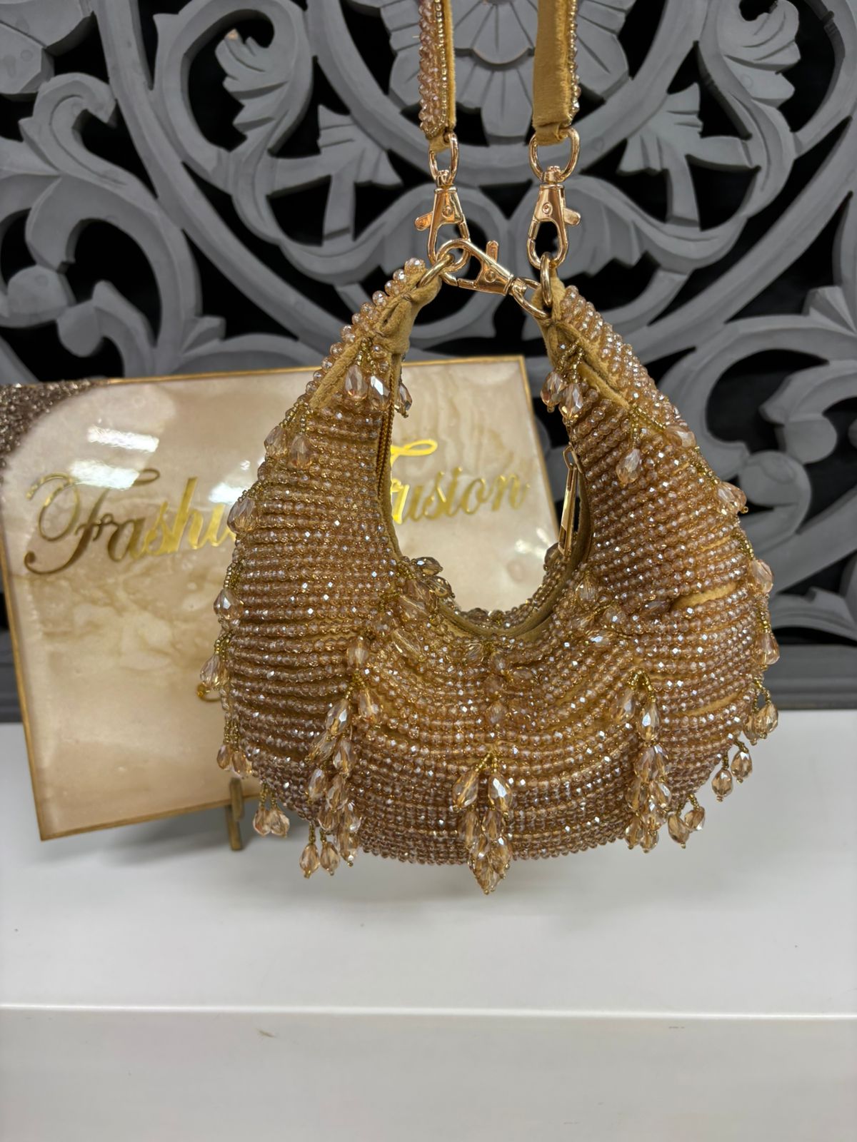 Gold beaded handbag with intricate design on a white surface