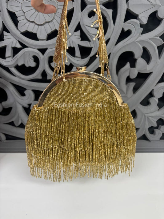 Gold beaded handbag with fringe details against a decorative black and white background.
