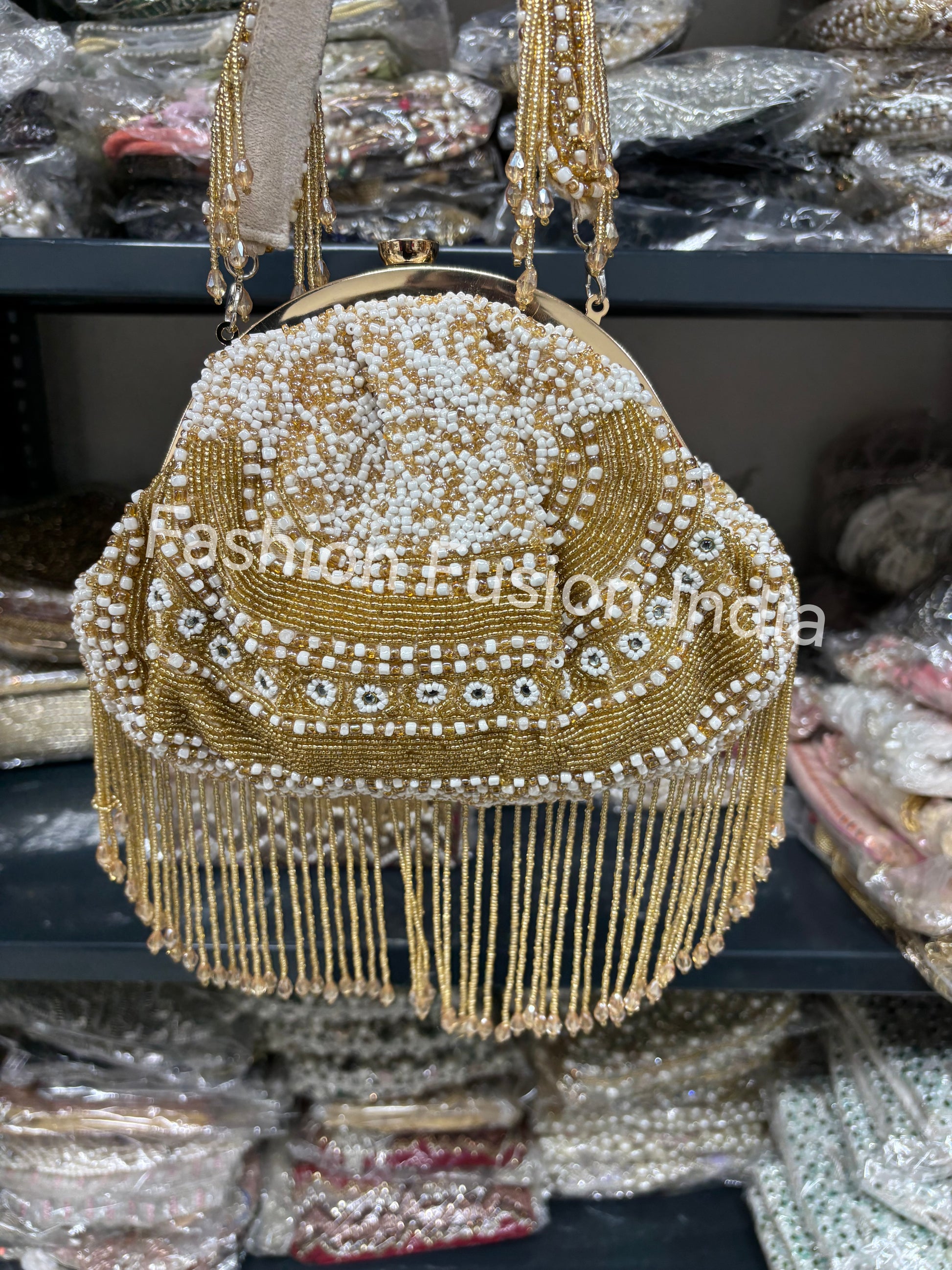 Gold beaded handbag with fringe details on a dark surface