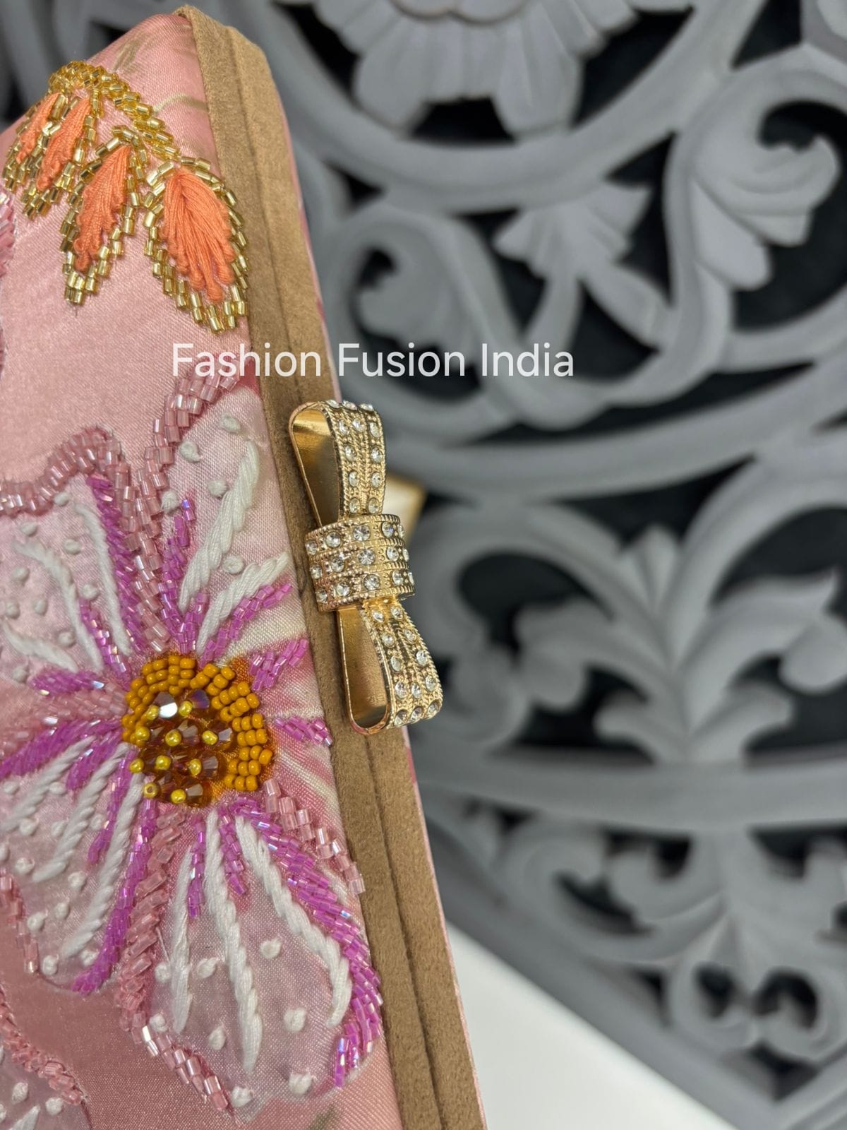 Decorative headband with floral embroidery and gold accents on a patterned background, featuring 'Fashion Fusion India' branding.