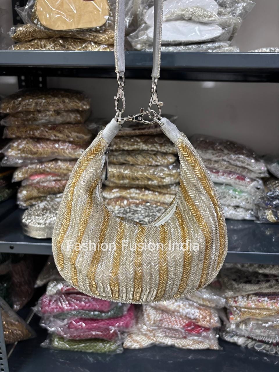 Gold and white handbag hanging against a background of packaged products.