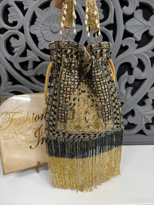 Decorative handbag with gold and black fringe and patterned background