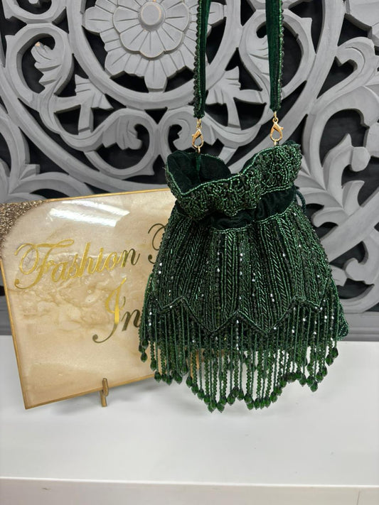 Green beaded dress on a stand with decorative background