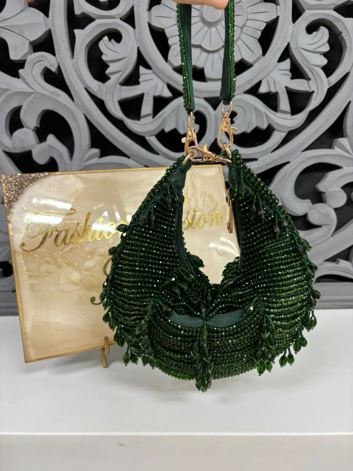 Green beaded necklace on a stand with decorative background