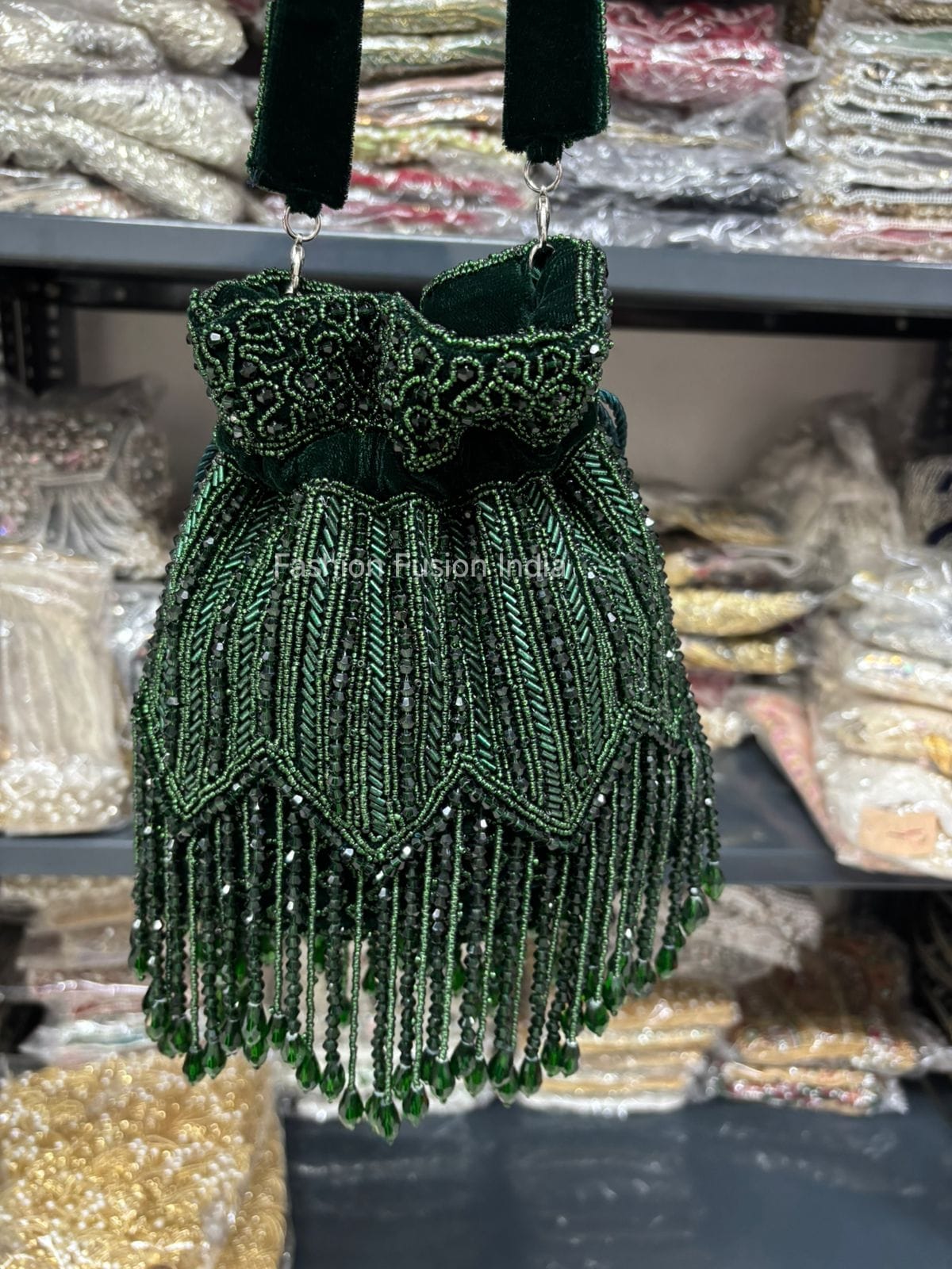 Green beaded handbag with fringes on a blurred background