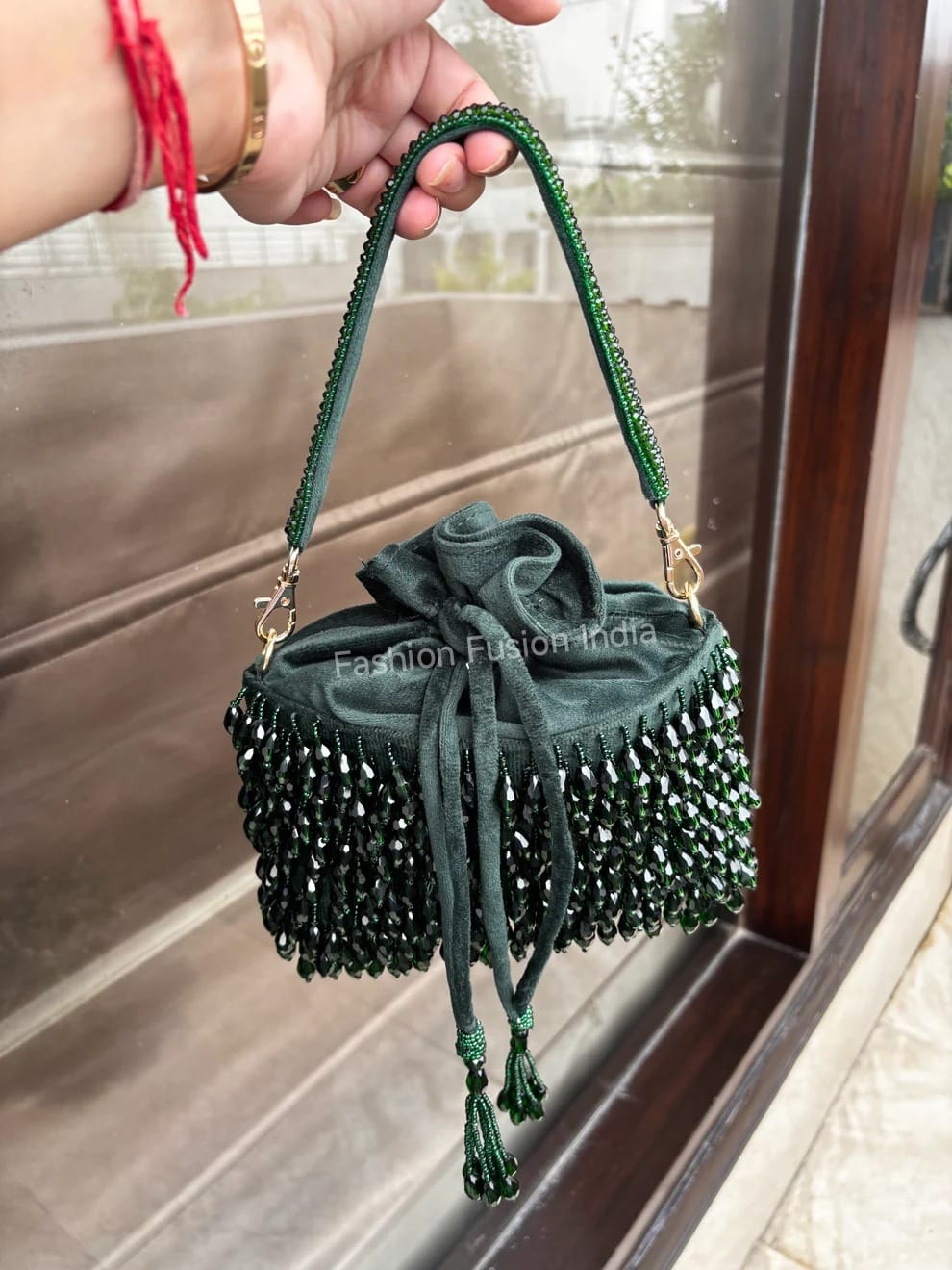 Handmade Green Crystals Bag – Velvet Finish with Sparkling Beadsheld by a hand with a blurred background
