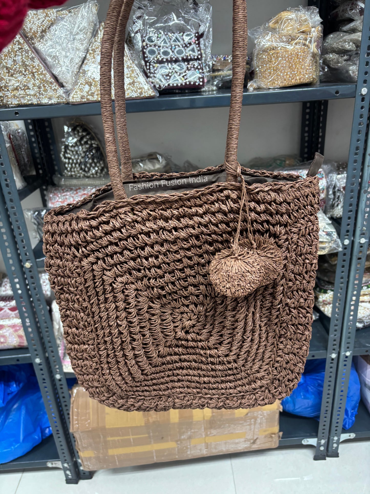 Brown crochet tote bag with pom-pom detail, handcrafted woven shoulder bag in natural fiber