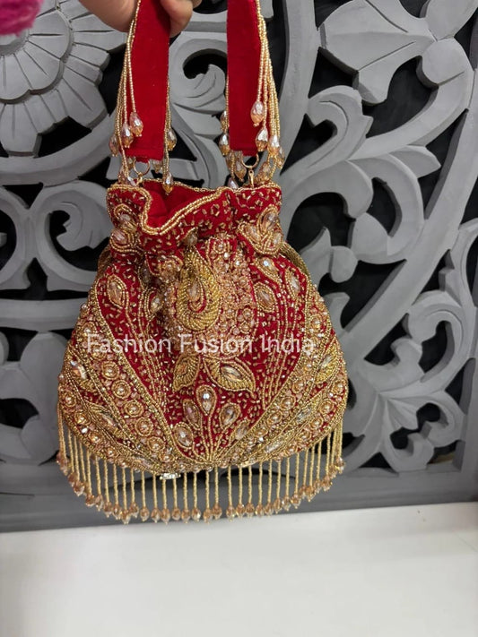 Decorative handbag with red and gold embroidery against a decorative white and black background.