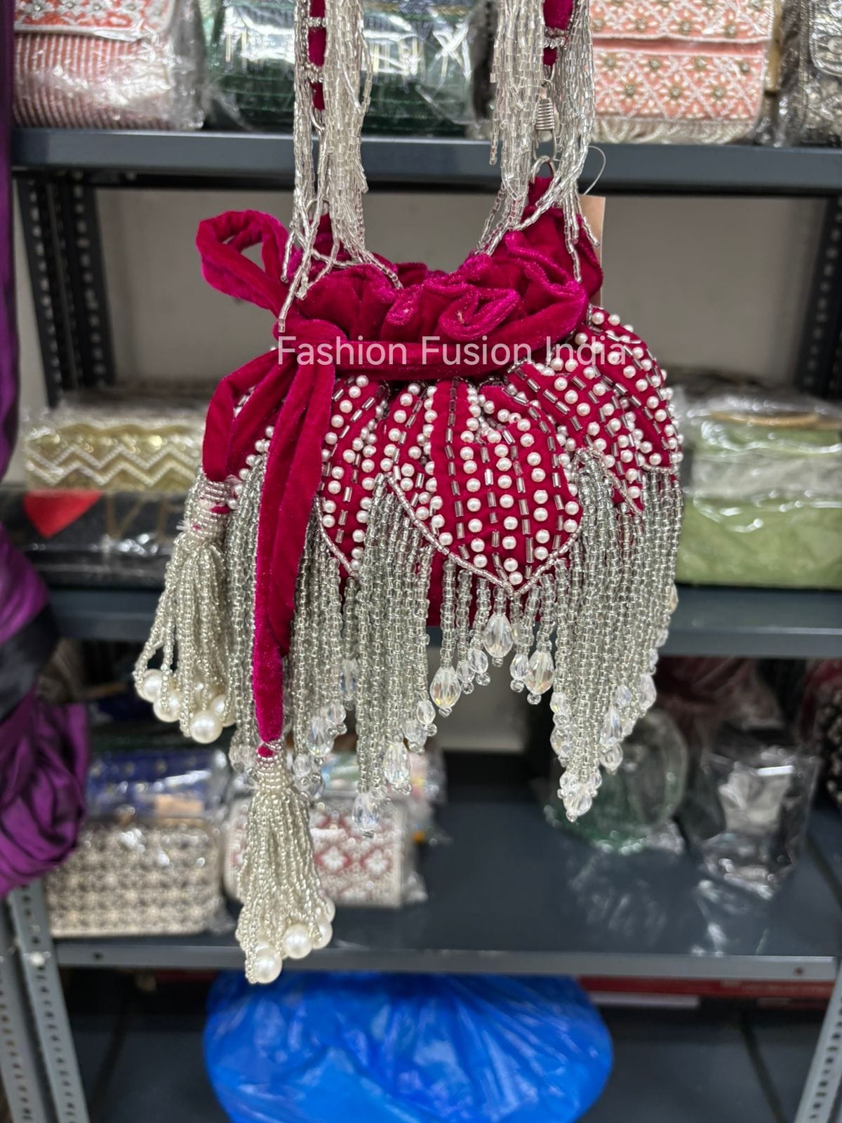 Decorative handbag with beads and ribbons on a shelf with 'Fashion Fusion India' branding.