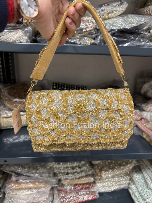 Gold beaded handbag held by a person with a blurred background of similar bags.