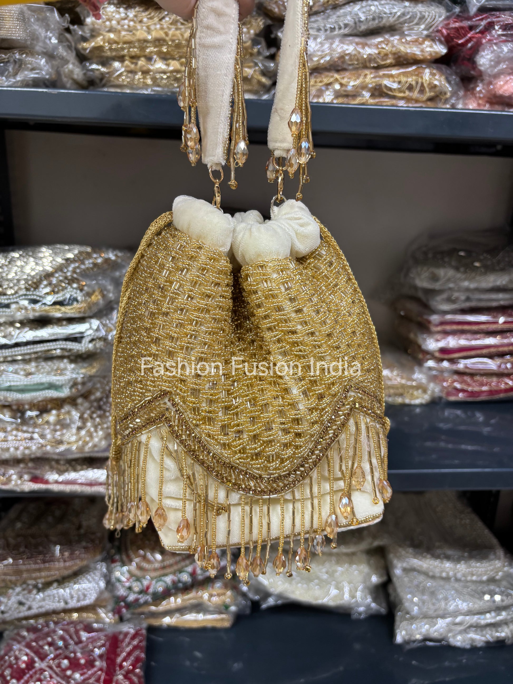 Gold and white handbag with decorative elements on a blurred background