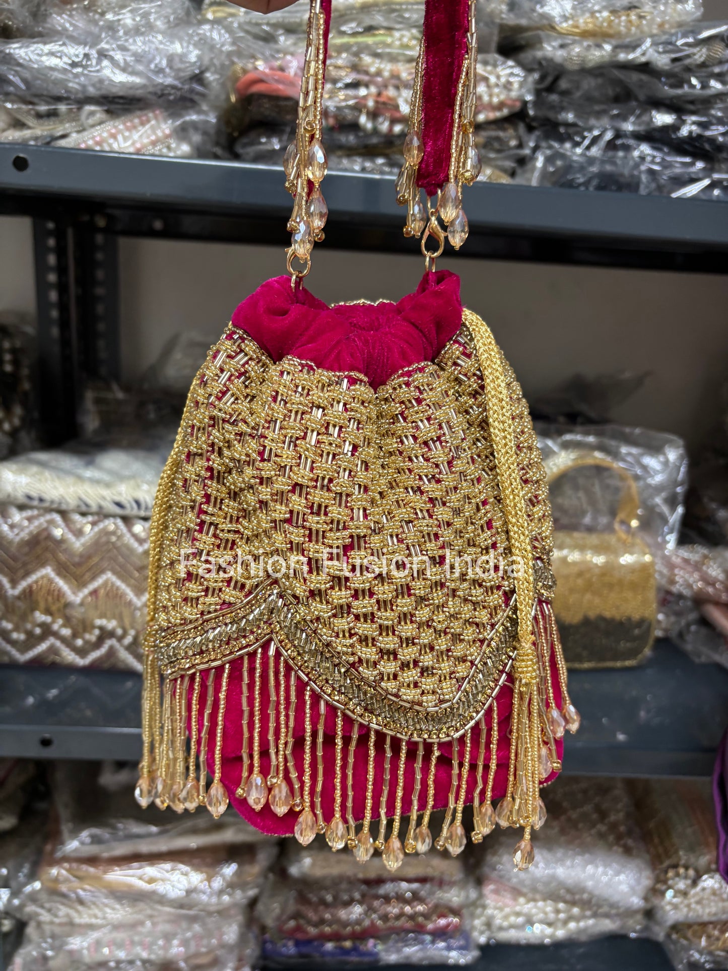 Decorative handbag with gold embroidery and red fabric, set against a blurred background.
