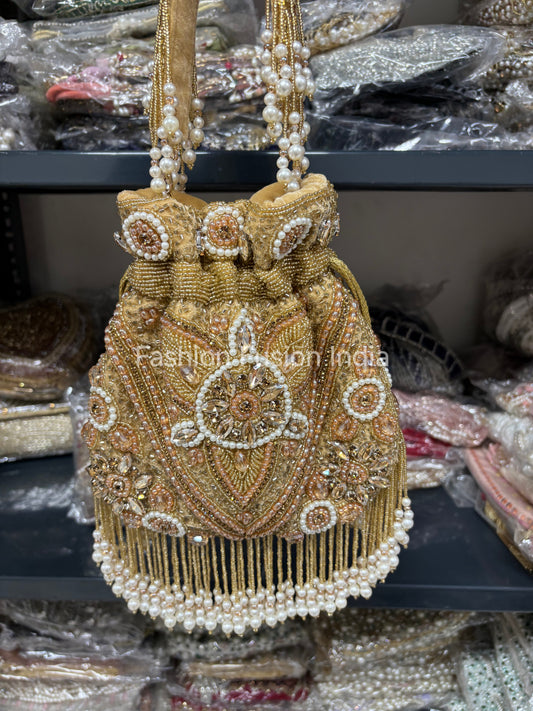 Gold beaded handbag with intricate designs on a blurred background