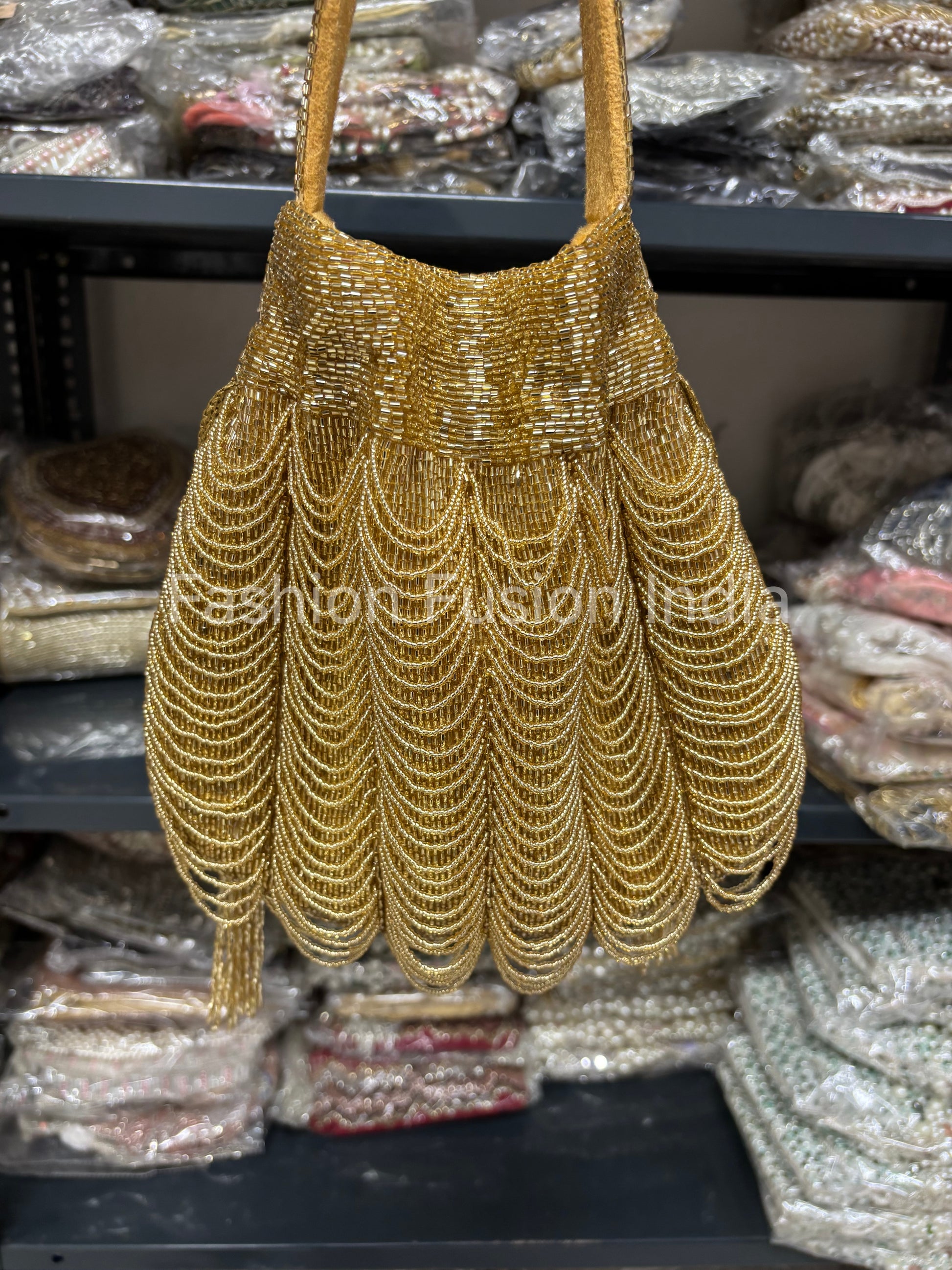 Gold beaded handbag on a shelf with other bags in the background
