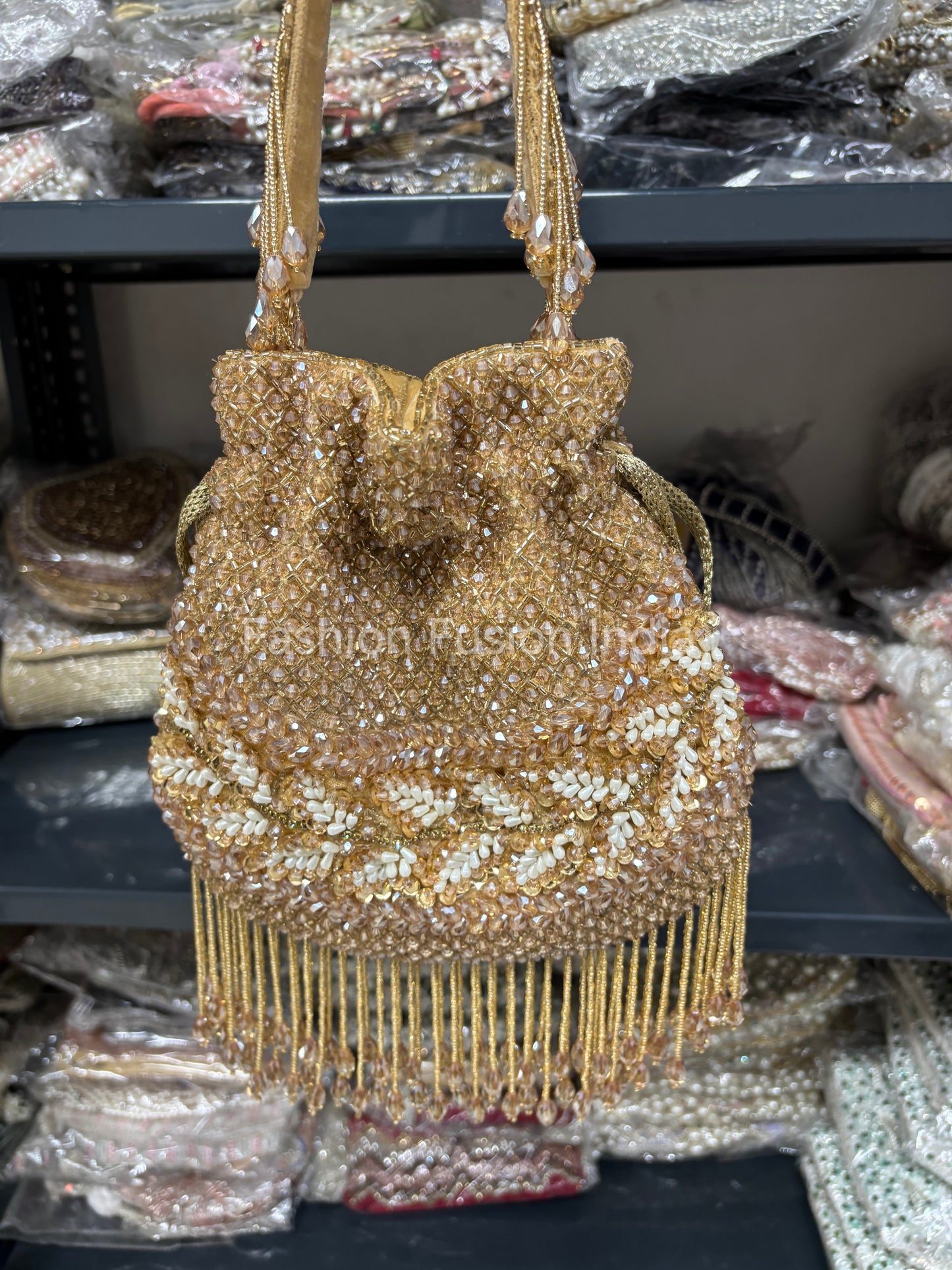 Gold beaded handbag with fringe on a blurred background