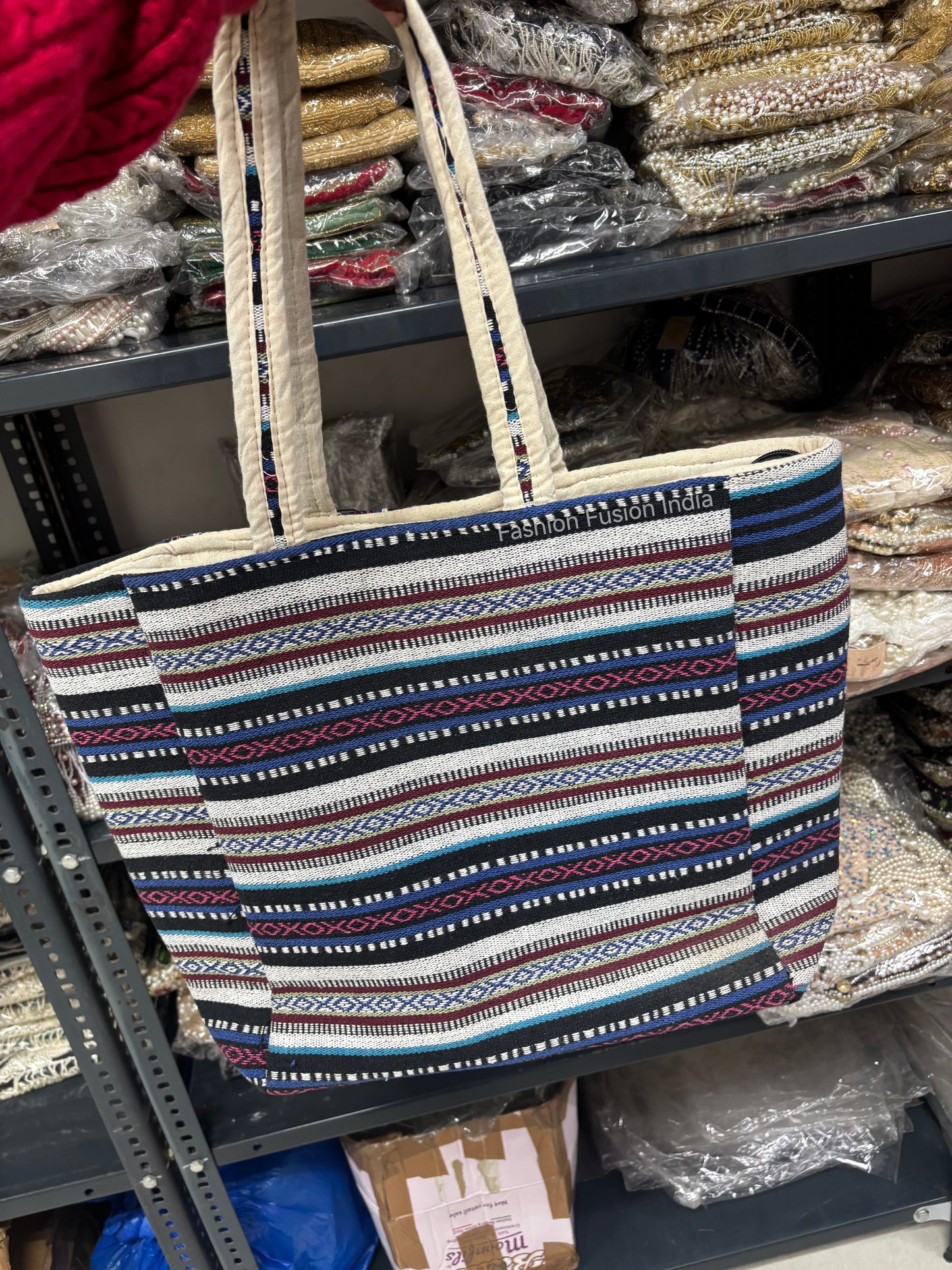 Patterned tote bag on a shelf with various items in the background