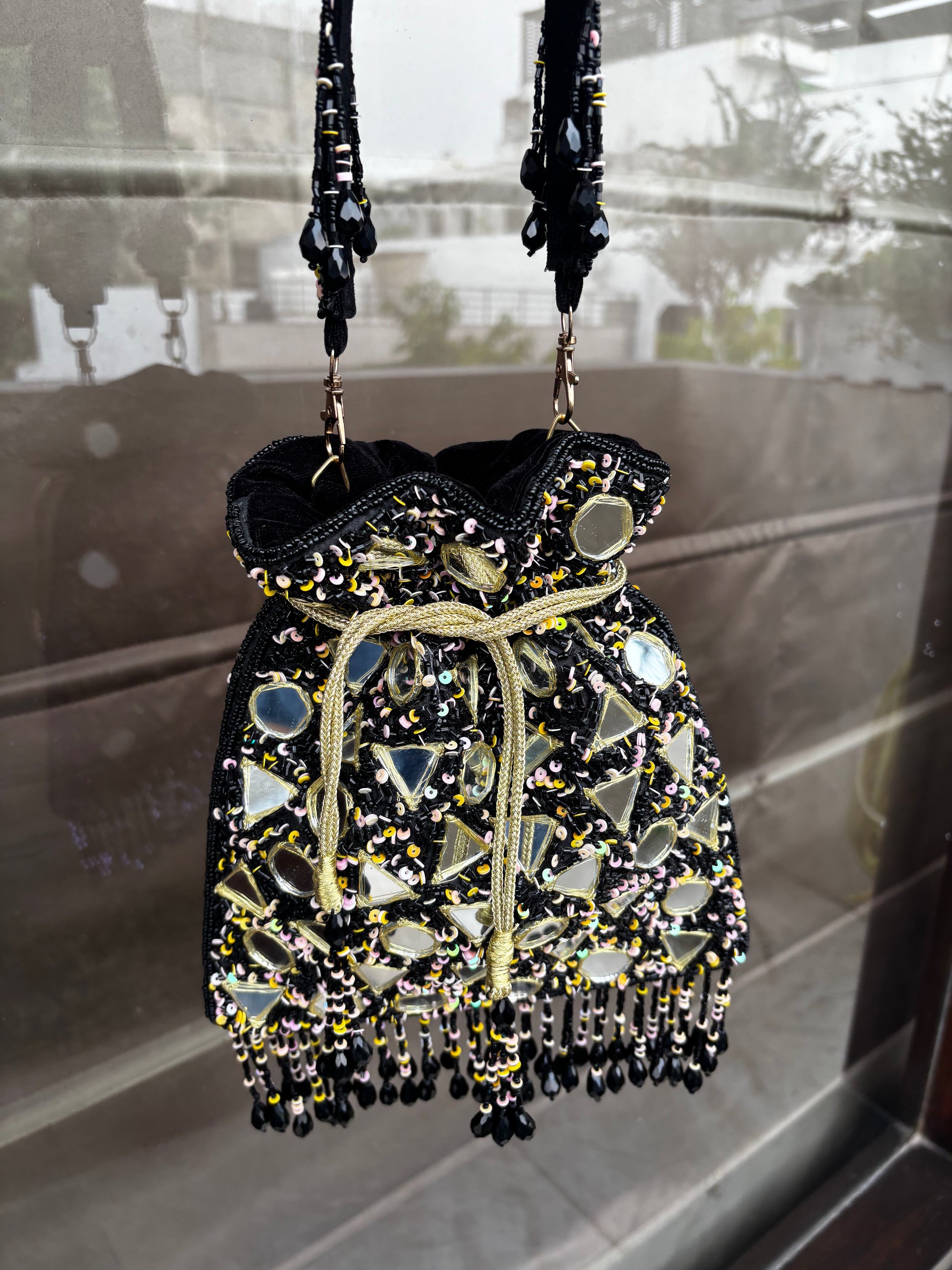 Decorative handbag with beads and mirrors on a reflective surface