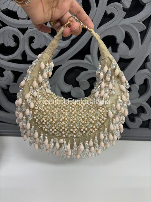 Decorative headpiece with beads and pearls held by a hand against a decorative wall.