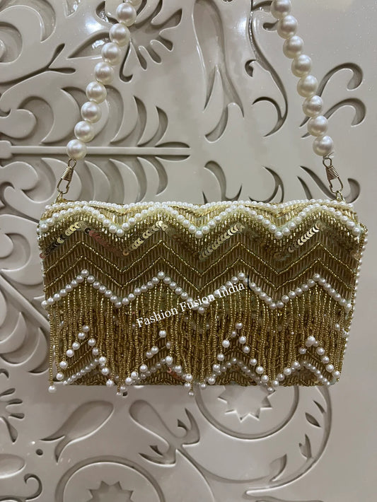 Gold beaded clutch with pearls on a decorative white background