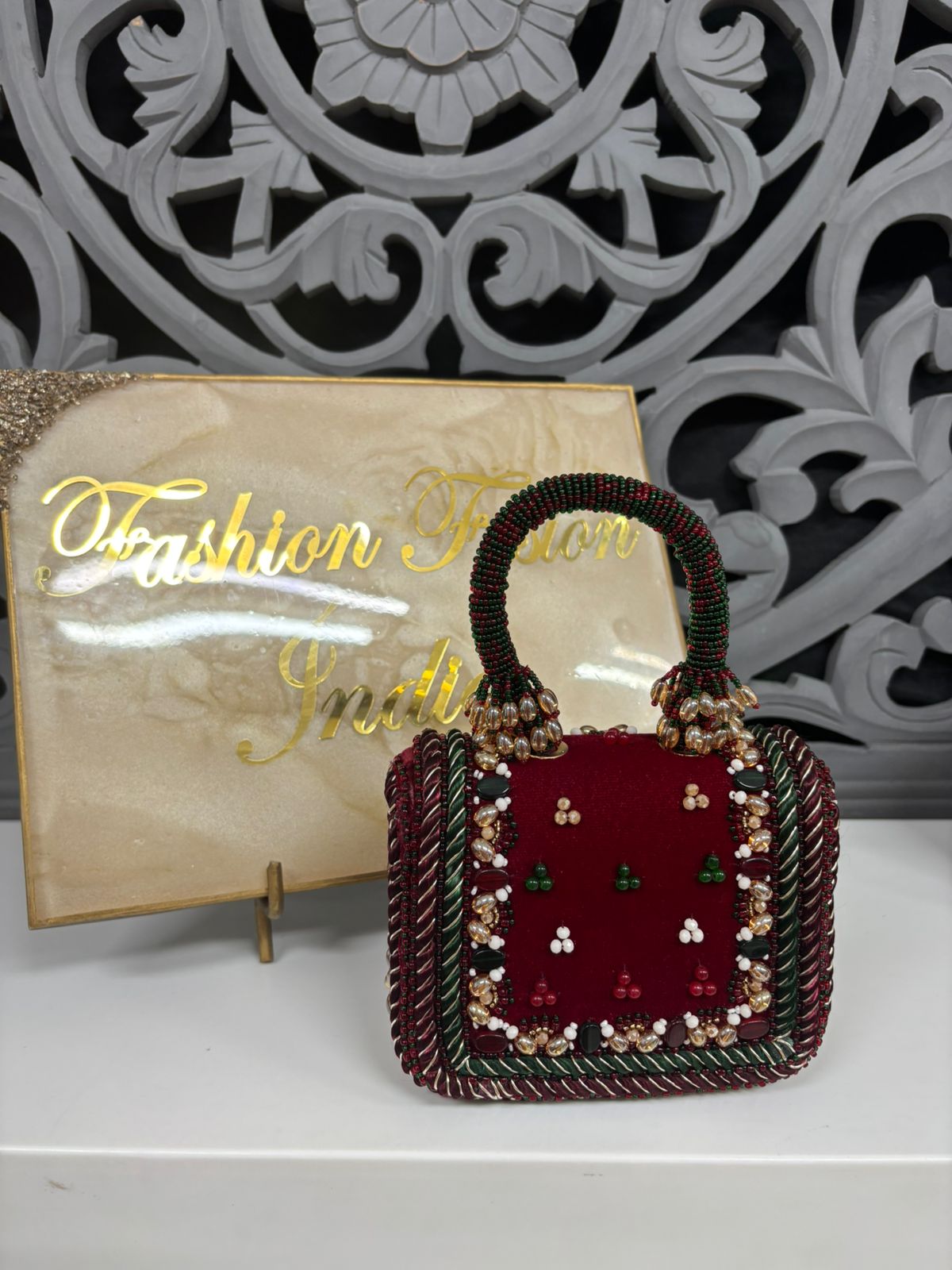 Decorative handbag with intricate design in front of a 'Fashion' sign.