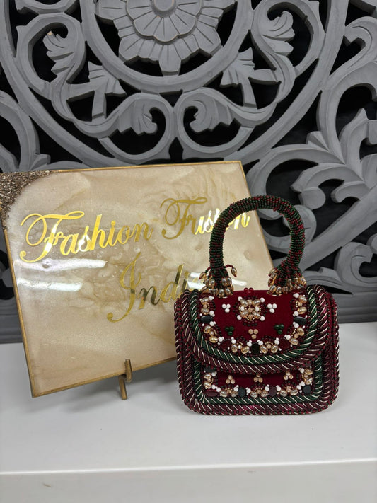 Decorative handbag with intricate designs in front of a 'Fashion Fusion India' sign.