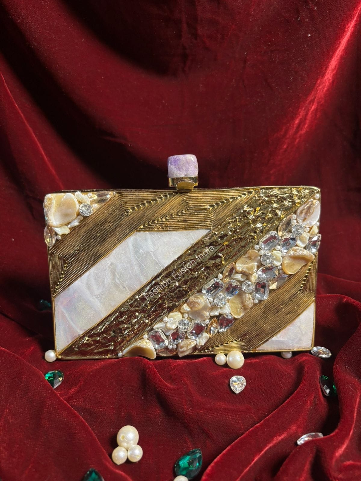 Decorative clutch bag with gold and white design on a red fabric background