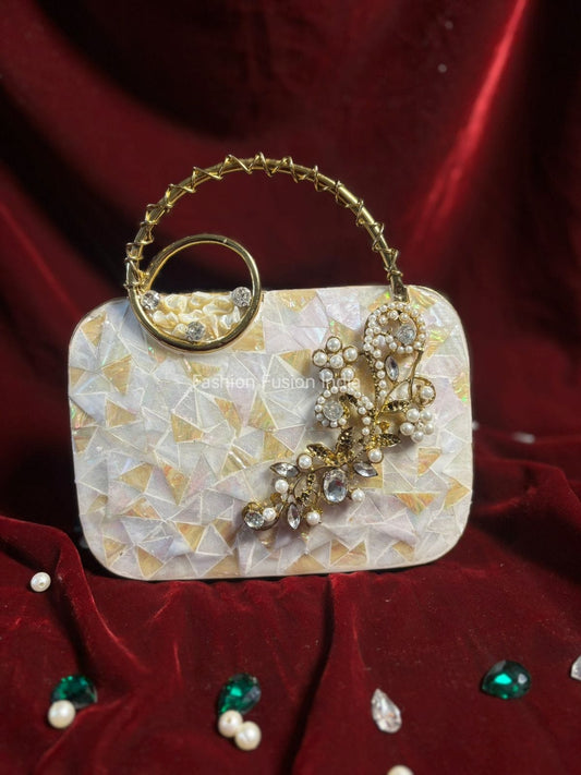 Decorative handbag with gold handle and embellishments on a red background
