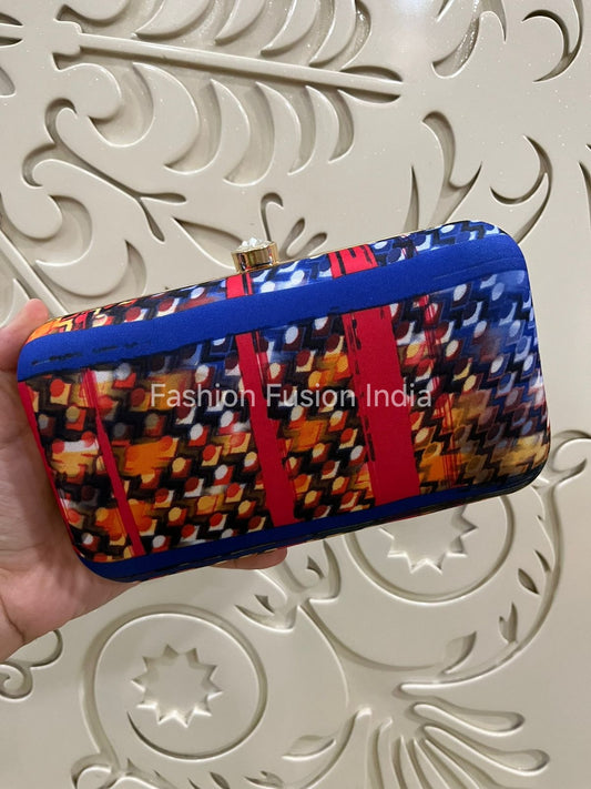 Colorful patterned clutch held by a hand against a decorative white background with 'Fashion Fusion India' branding.