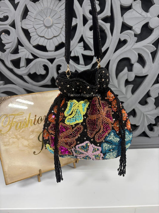 Colorful beaded handbag with floral patterns against a decorative wall.