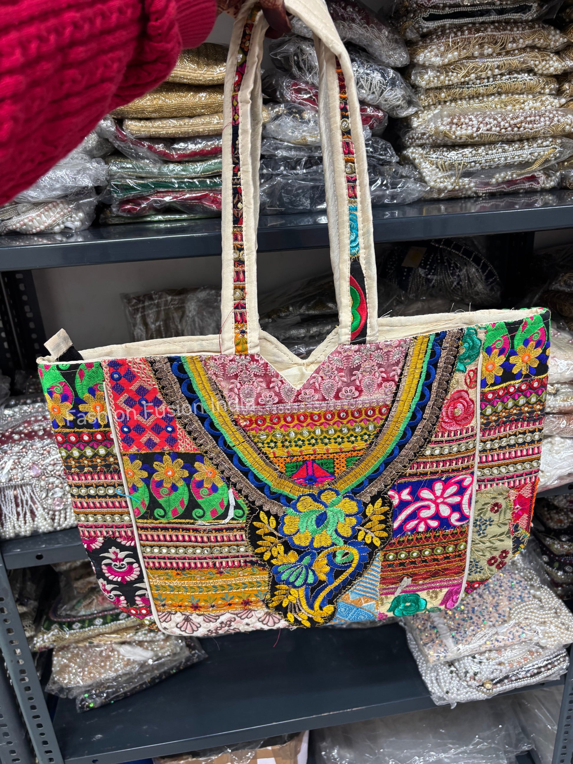 Colorful embroidered bag on a shelf with various items in the background