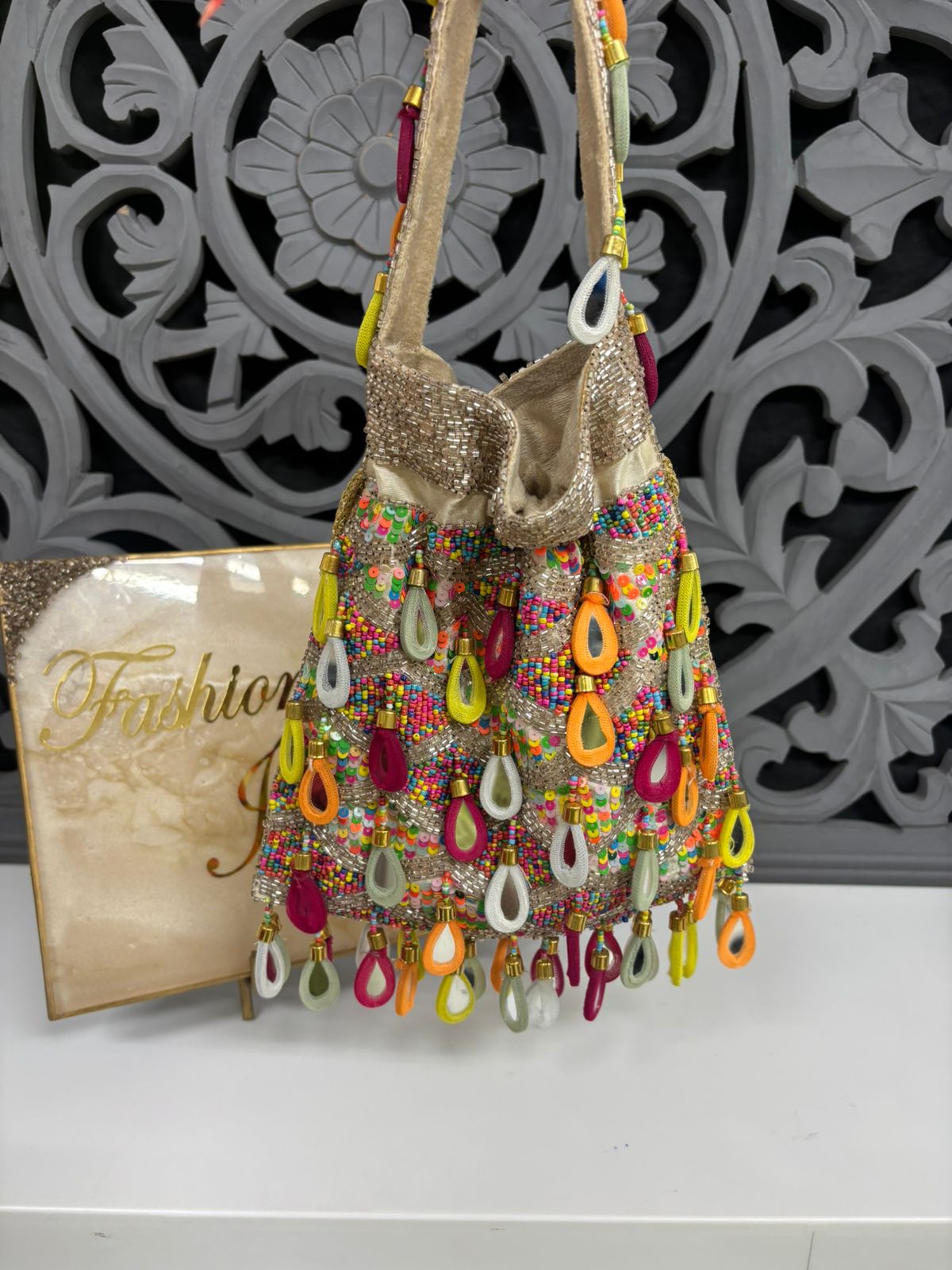 Colorful beaded handbag with decorative elements on a white surface.