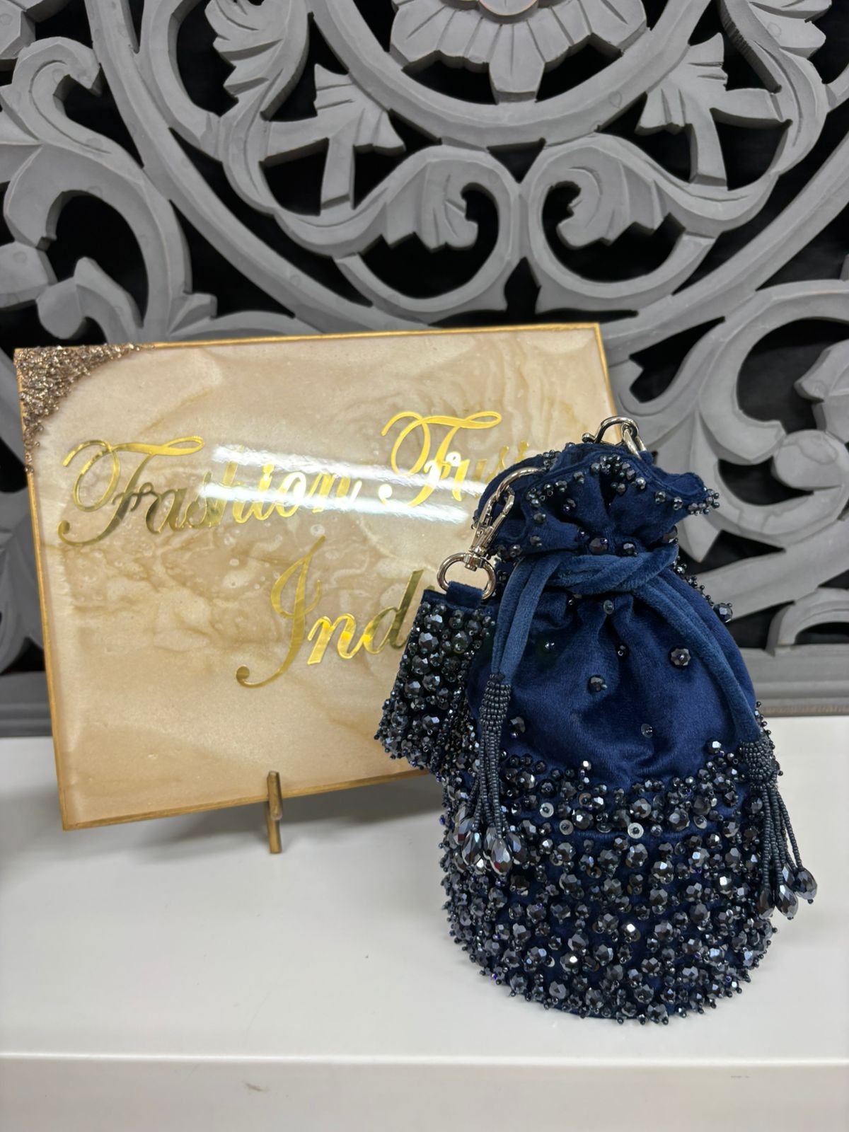 Blue beaded drawstring bag with decorative box in the background
