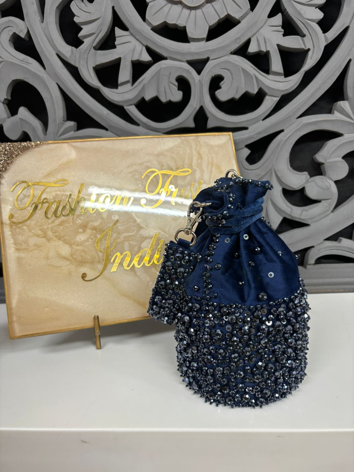 Navy blue beaded bag with a decorative background