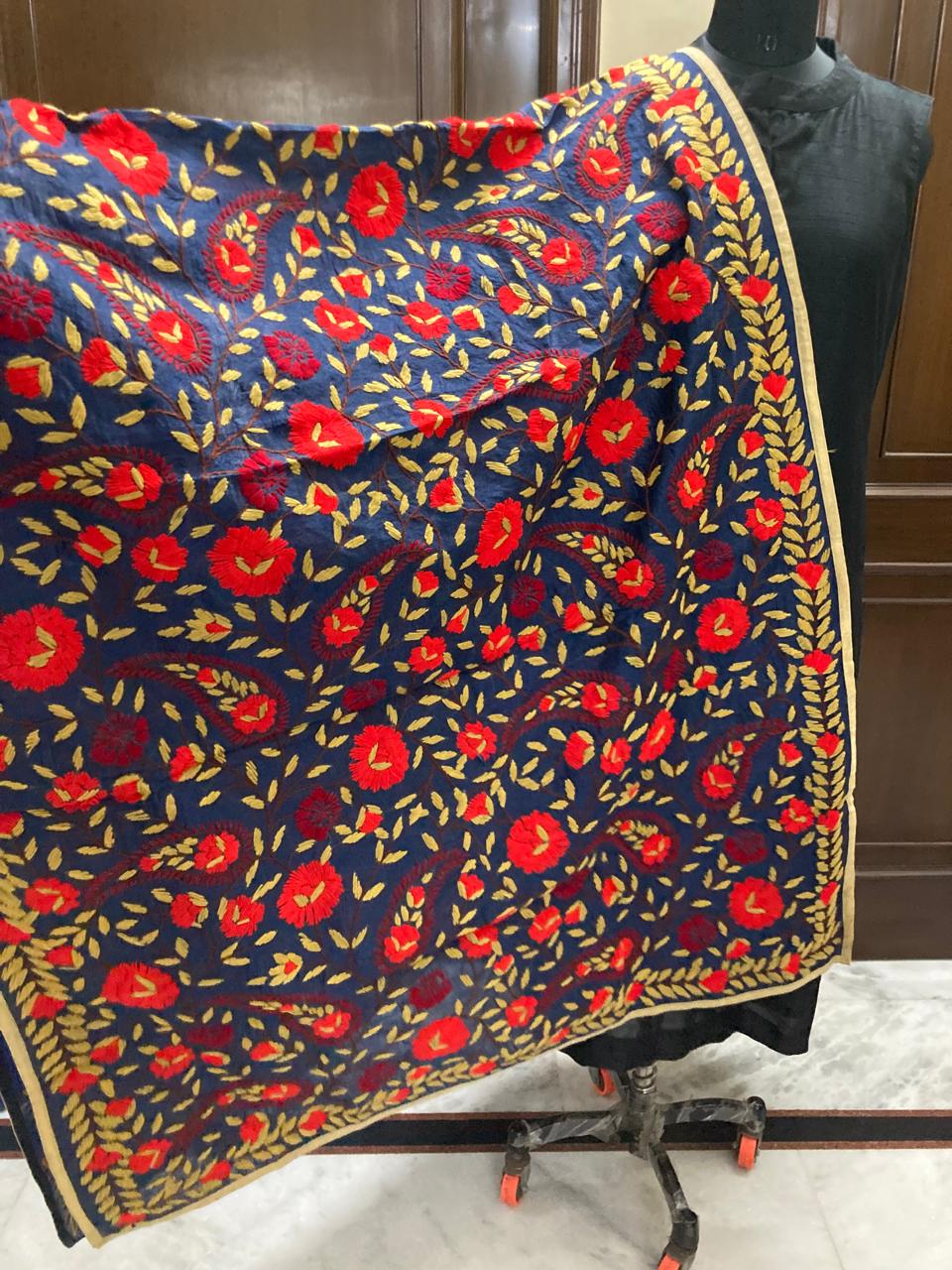 Floral patterned fabric draped over a mannequin against a wooden background