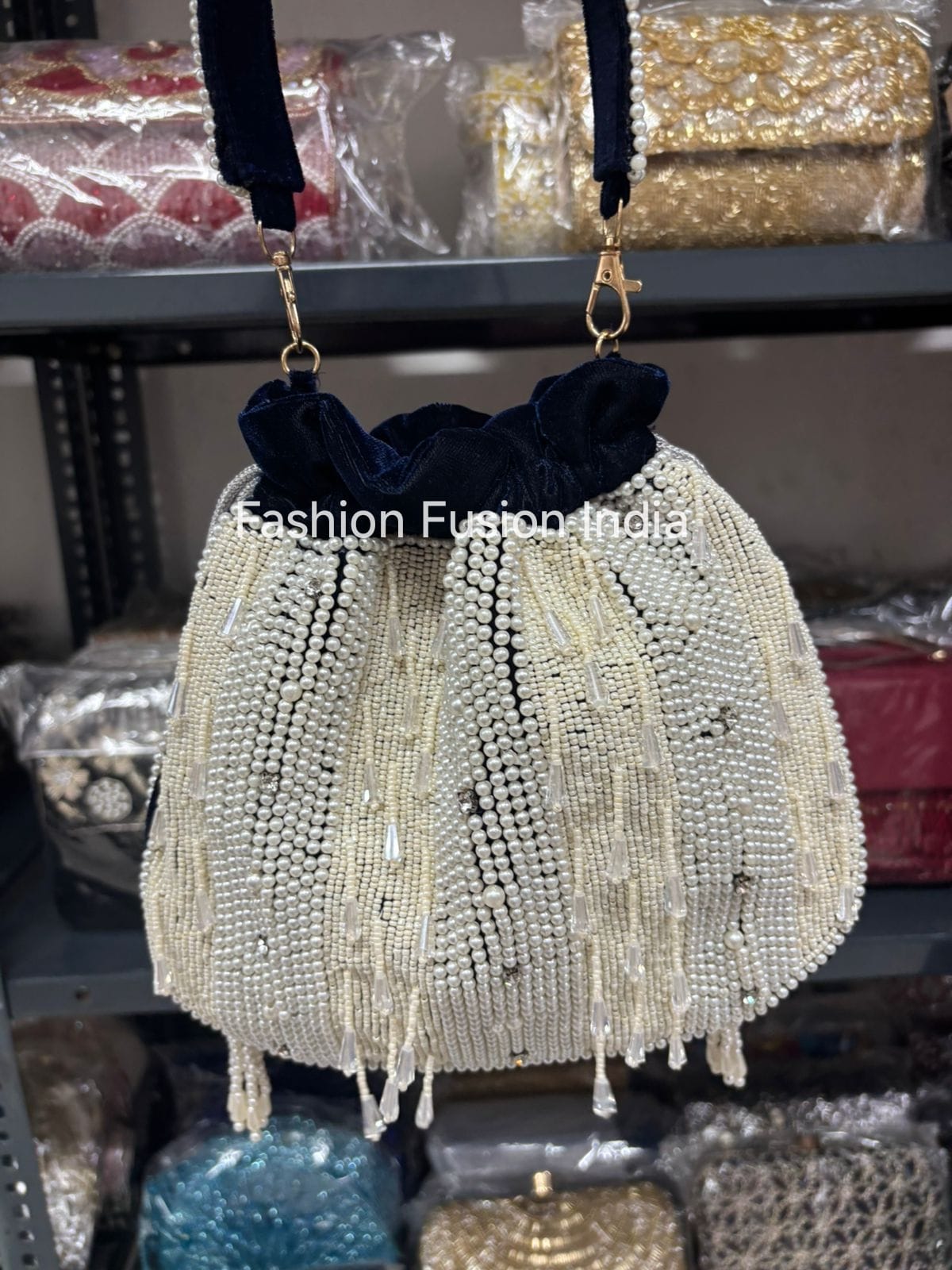 Beaded handbag with tassels on a shelf with 'Fashion Fusion India' branding.