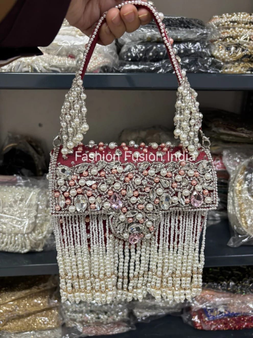 Decorative handbag with beads and fringes, branded 'Fashion Fashion India', held by a person.