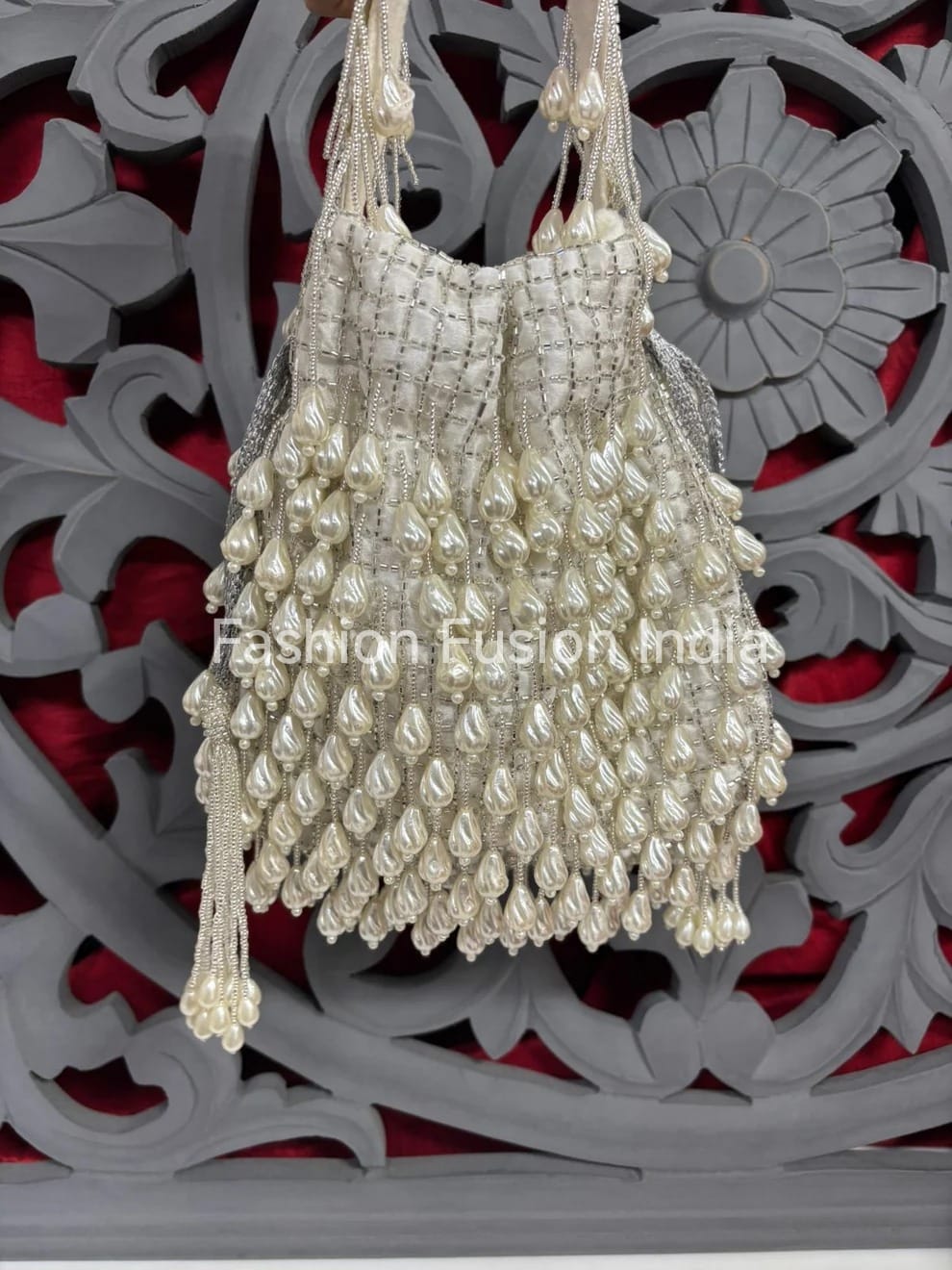 Decorative handbag with pearl-like beads against a decorative background