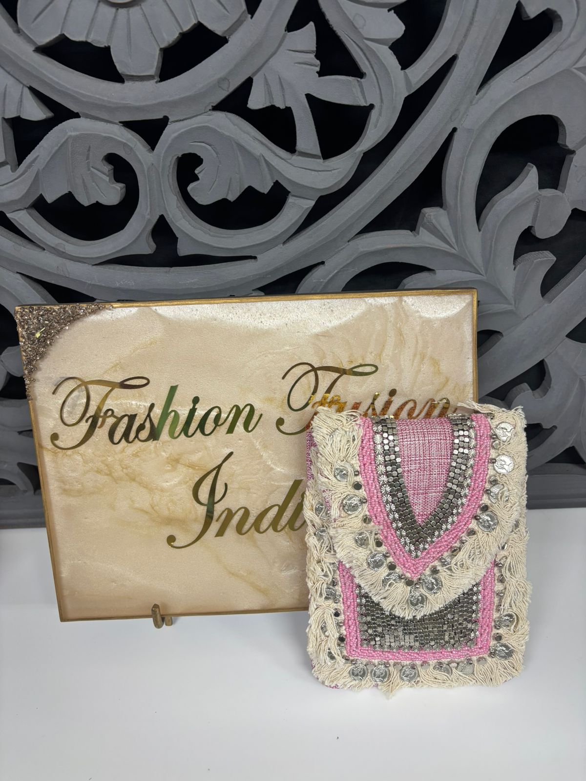 Decorative clutch bag with intricate designs next to a 'Fashion Indian' sign.