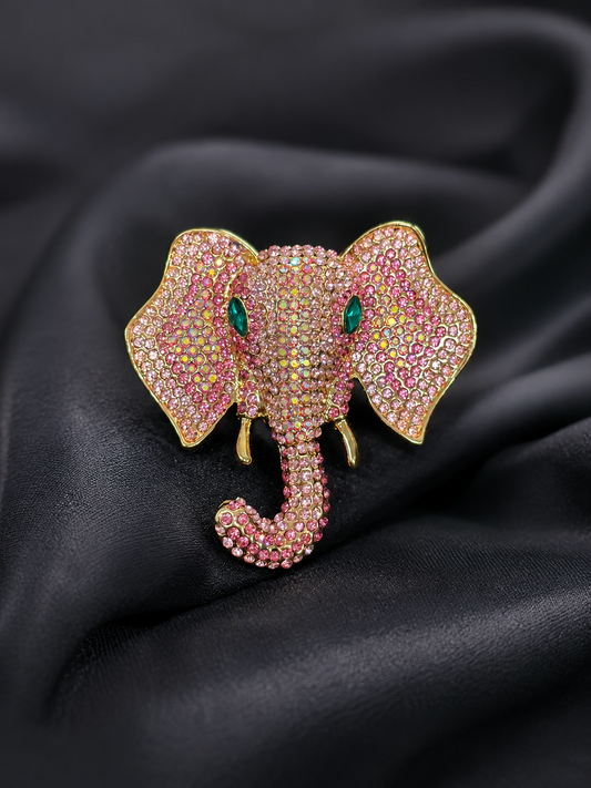 Pink elephant brooch with gemstones on a black satin background