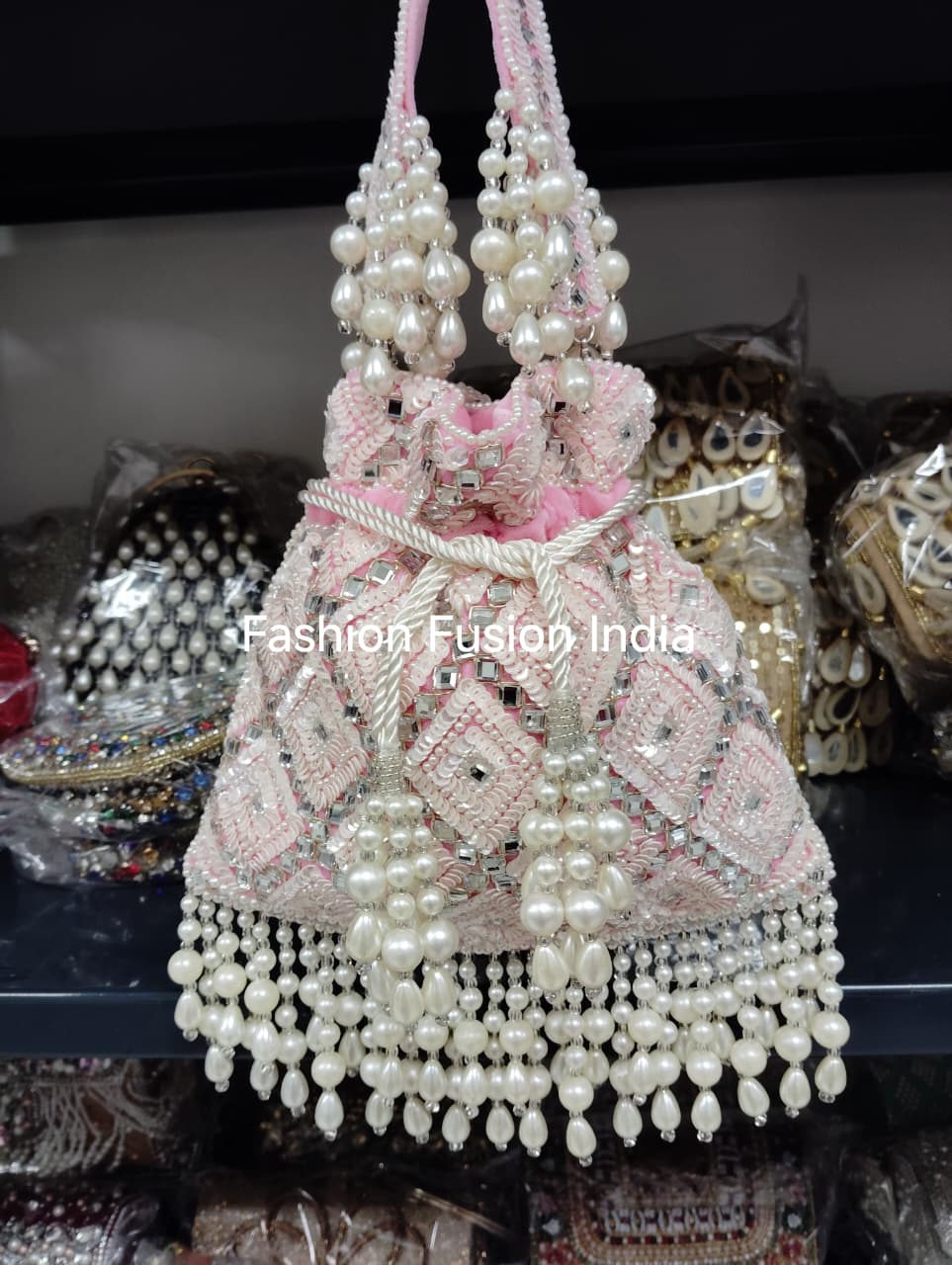 Decorative handbag with pearls and pink accents on a dark background