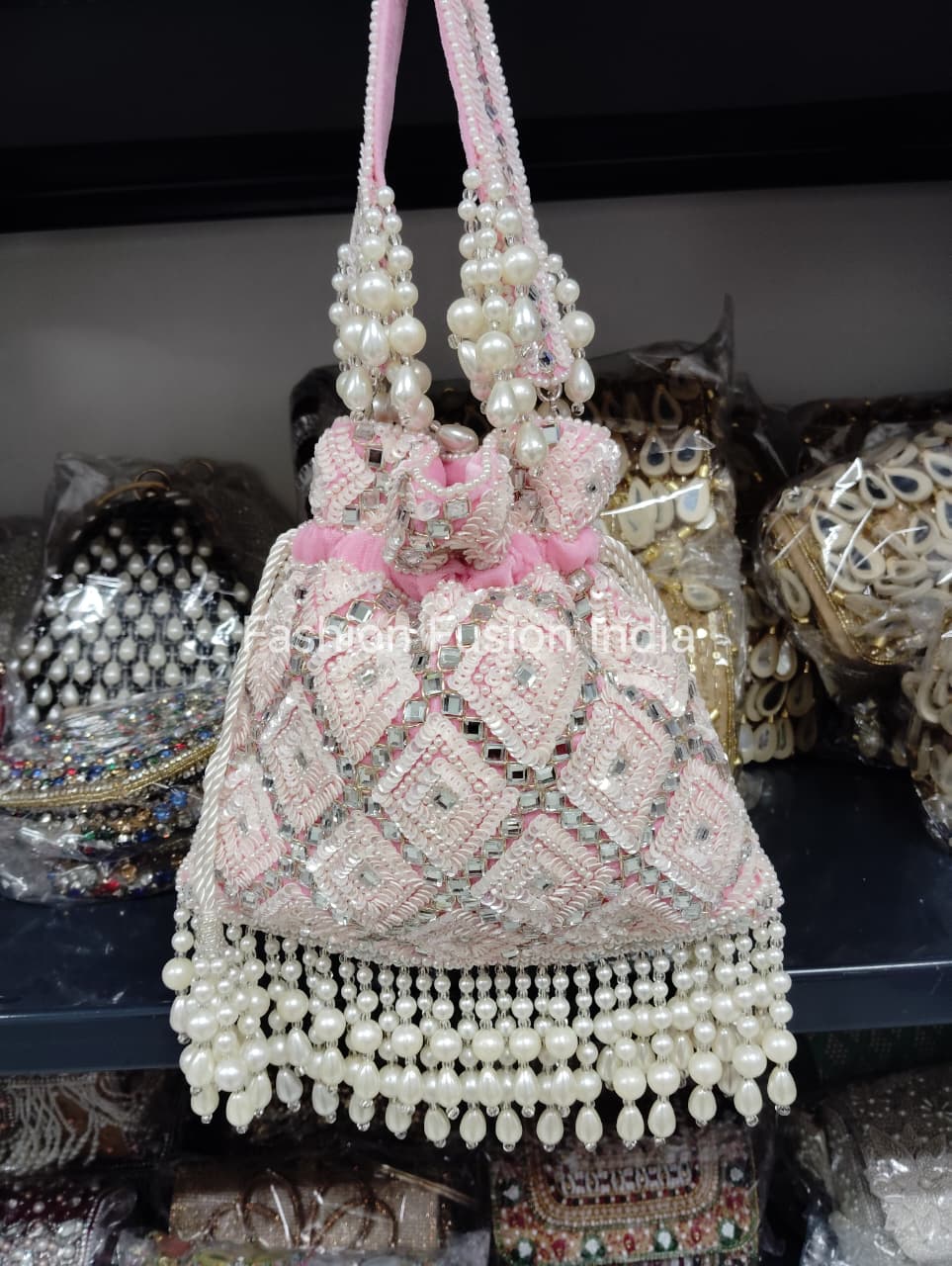 Decorative handbag with pearls and pink accents on a dark background