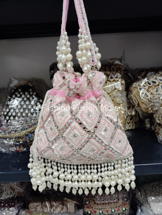Decorative handbag with pearls and pink accents on a dark background