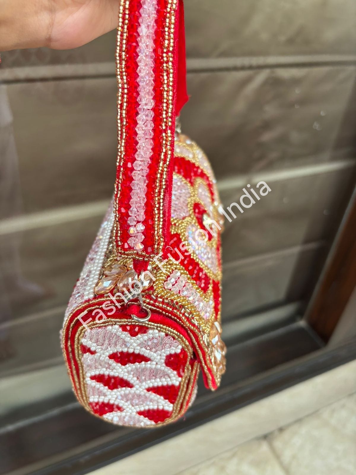 Decorative sandal with red and white pattern on a metallic surface