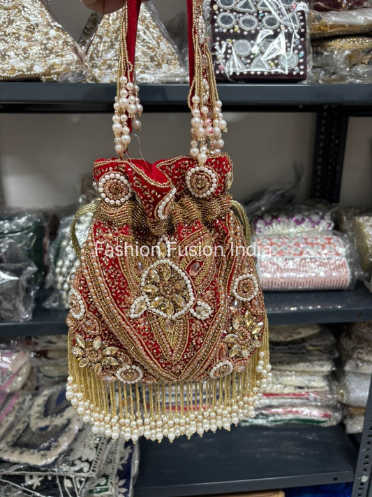 Decorative handbag with intricate designs and pearl details on a blurred background.